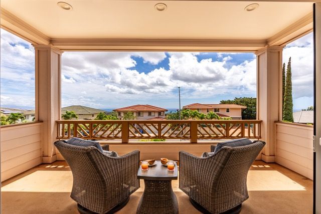 A balcony with two wicker chairs and a table