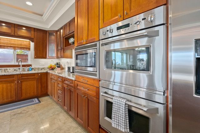 A kitchen with stainless steel appliances and wooden cabinets.