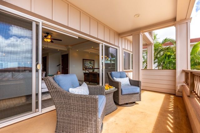 There are two chairs and a table on the balcony.