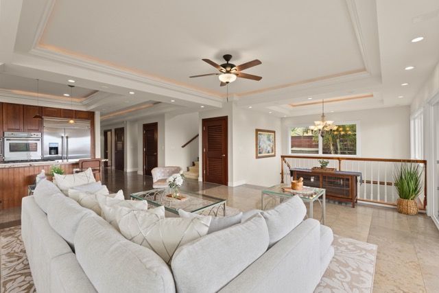 A living room with a large white couch and a ceiling fan.