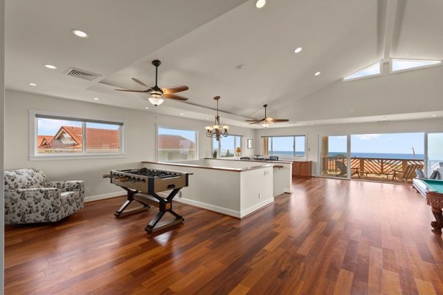 A living room with hardwood floors and a pool table.