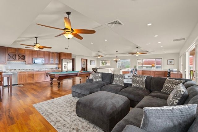 A living room with a pool table and a ceiling fan