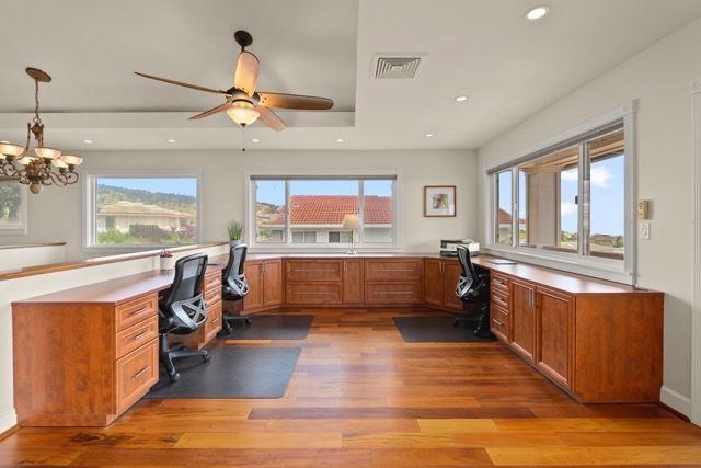 A large room with hardwood floors and a ceiling fan.