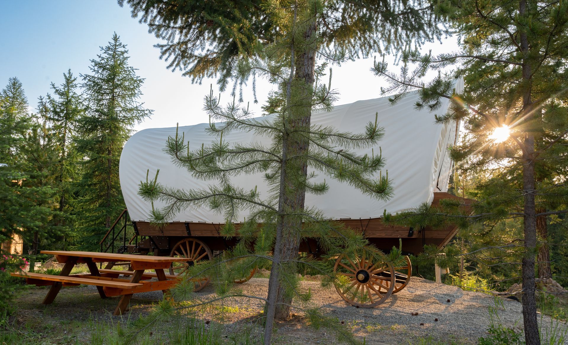 A covered wagon with a picnic table in front of it