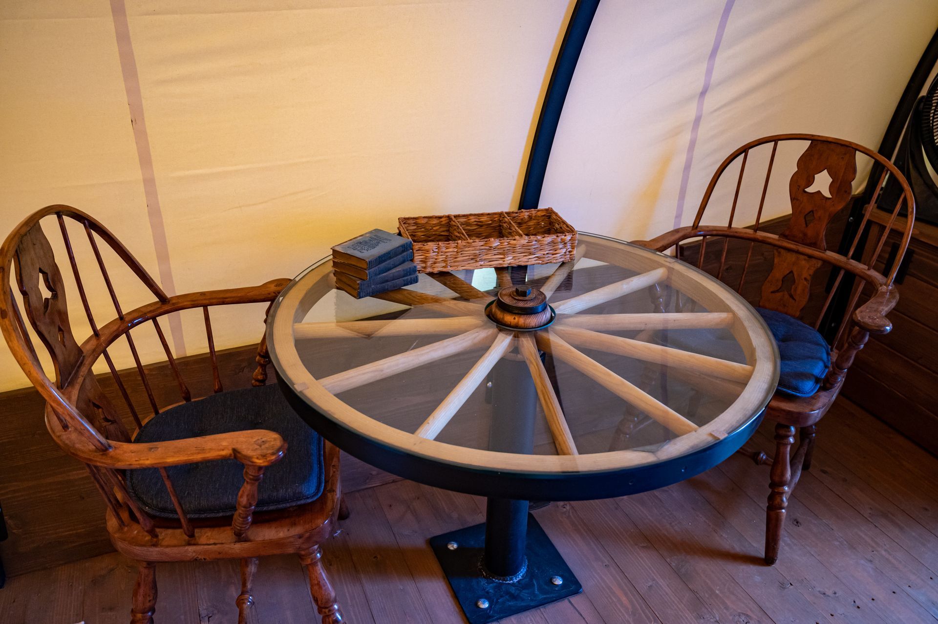A table made out of a wagon wheel and two chairs