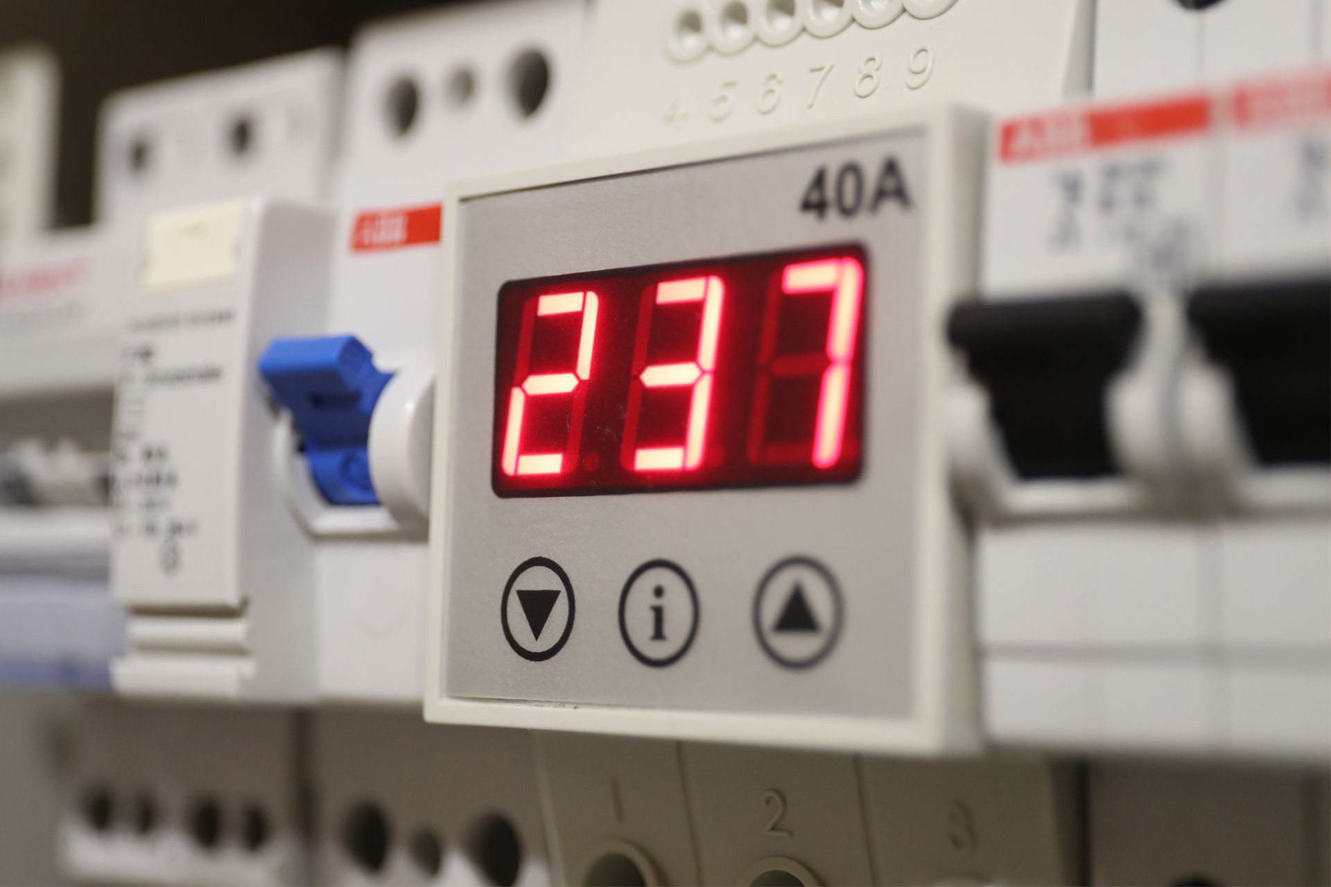 Red digital display on an electrical panel showing 237, with blue and black switches nearby.