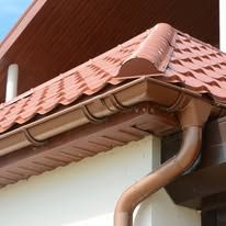 White house eaves and gutter against a clear blue sky