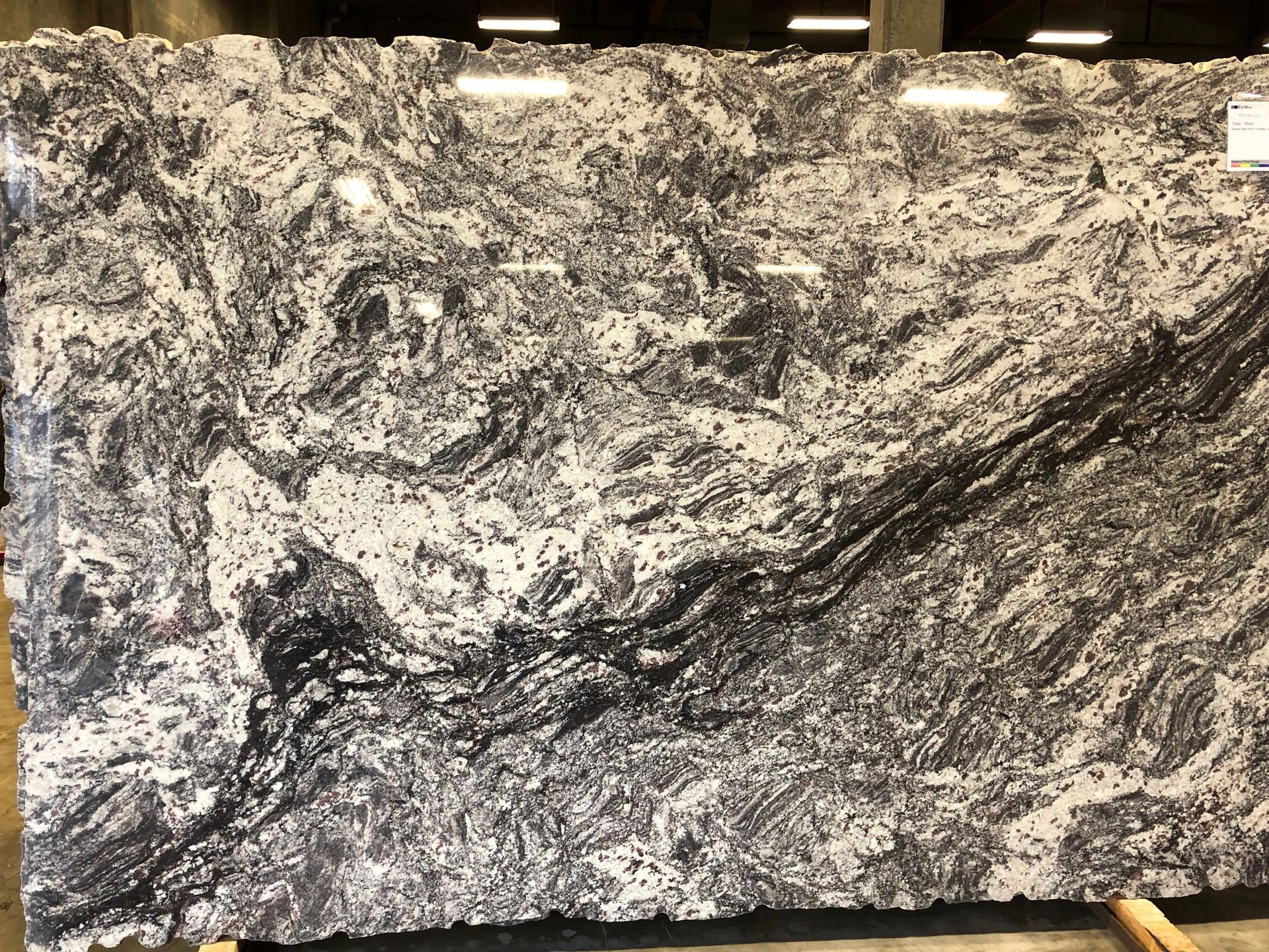Black, white, and gray marbled stone slab with swirling veins and layered patterns