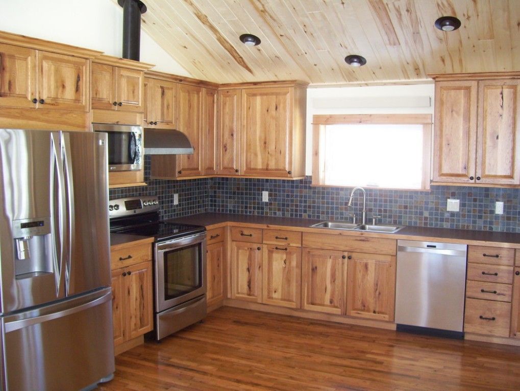 Spacious kitchen with wood cabinets, stainless steel appliances, tiled backsplash, and a large window.
