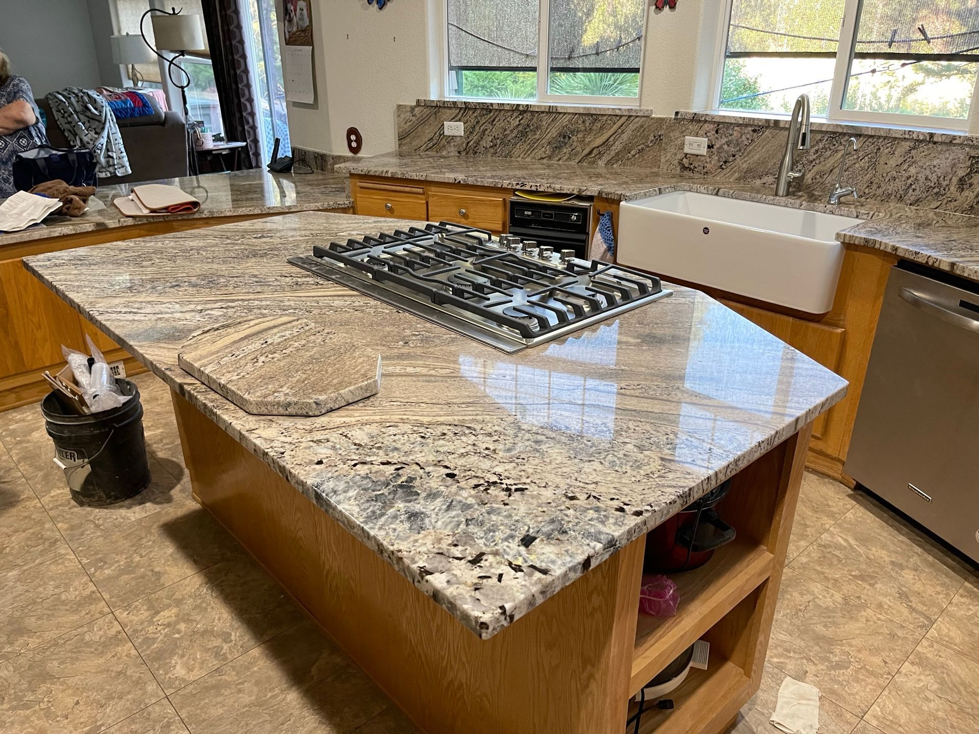 Kitchen island with granite countertop and gas cooktop in a bright modern kitchen