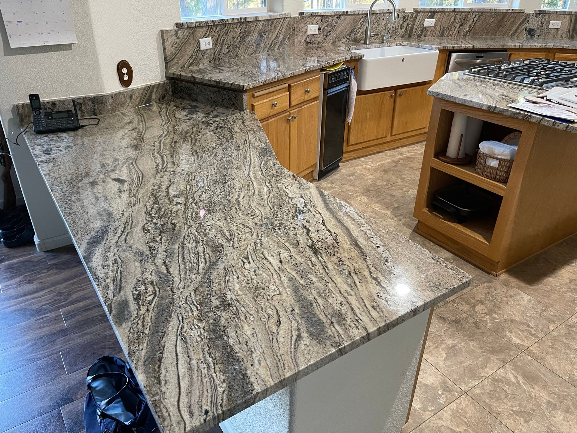 Kitchen with granite countertops, wooden cabinets, and a central island in a bright home interior