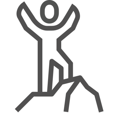 Person with arms raised atop rocky terrain.