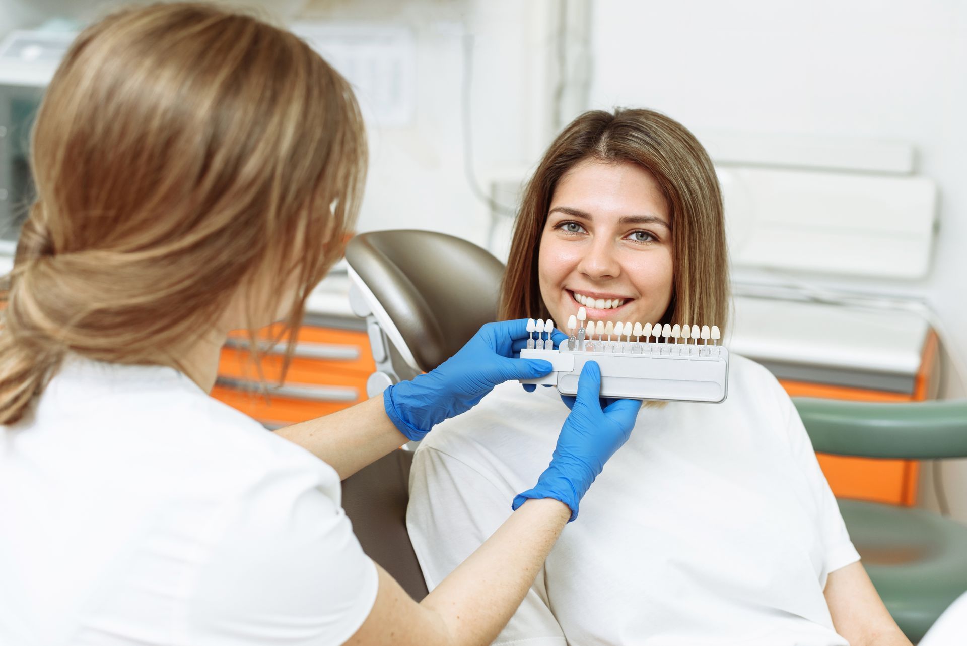 Dentist showing dental x-ray to smiling patient in a bright clinic