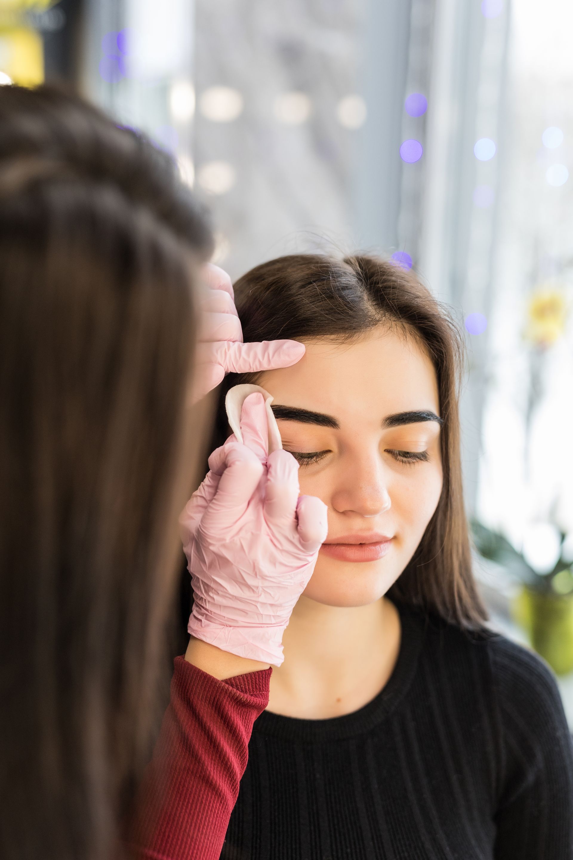 a woman is getting her eyebrows painted in a beauty salon .