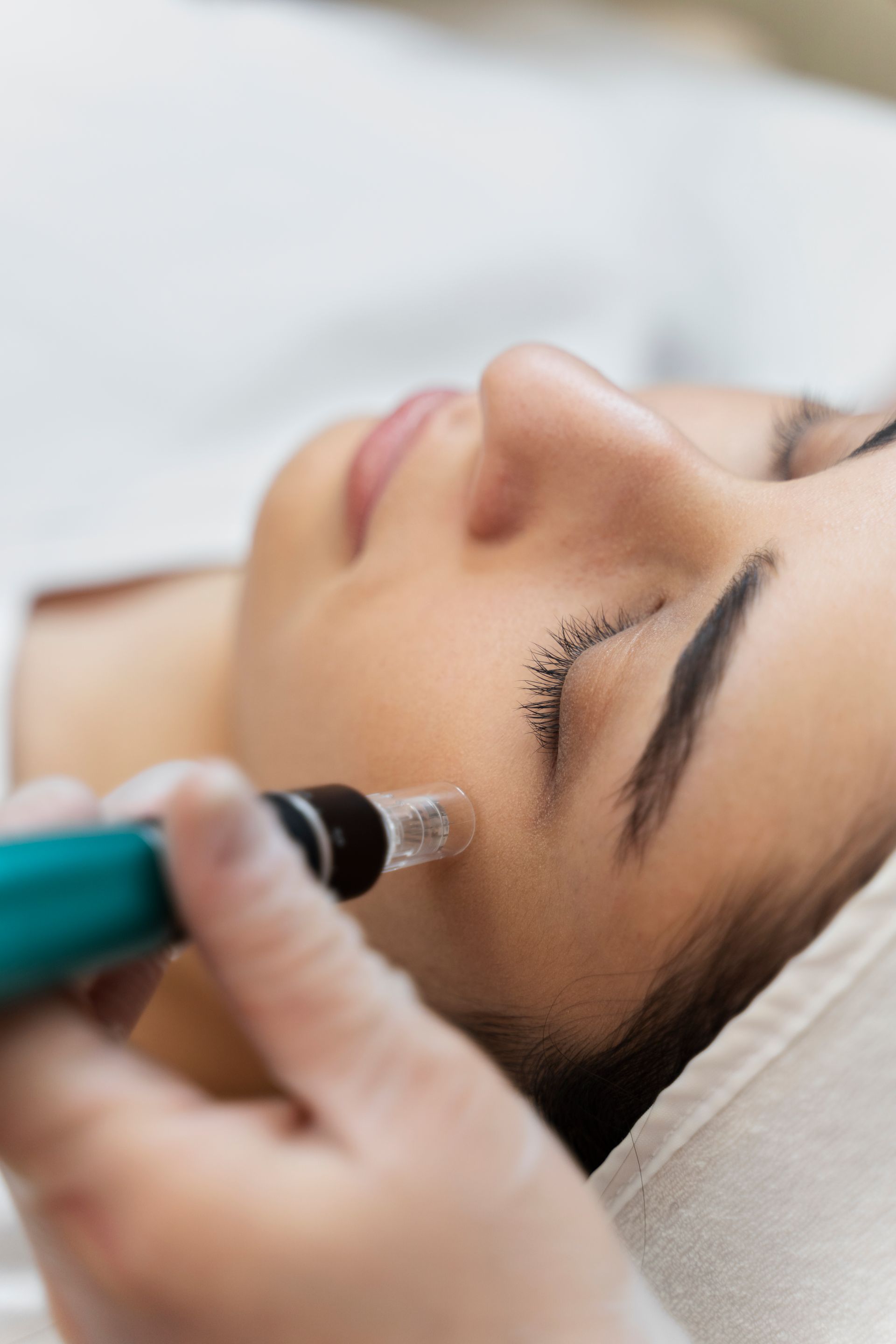 a woman is getting a facial treatment with a pen on her face .
