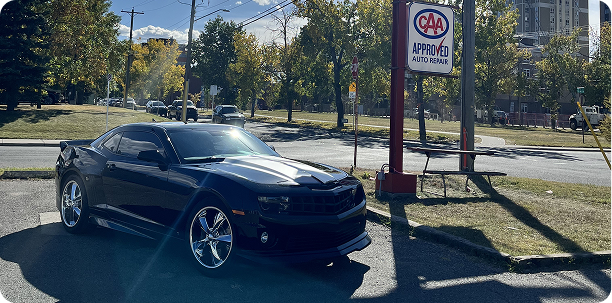 Black Chevrolet Camaro parked in front of an 