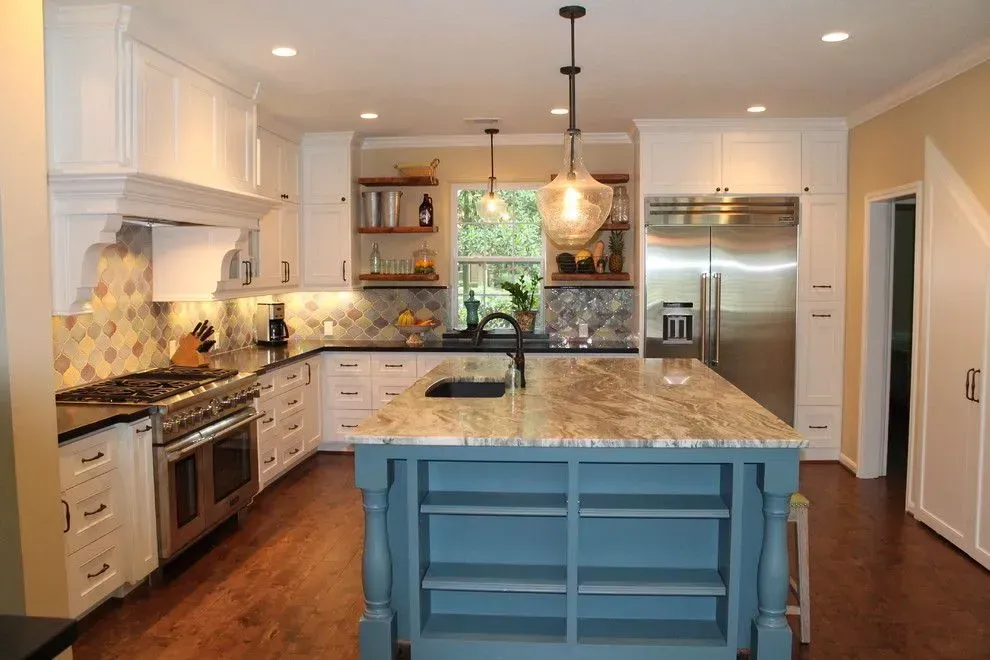 Bright modern kitchen with white cabinets, granite island, stainless steel appliances, and blue island base
