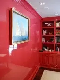 Bright red room with built-in shelves and a framed sailboat painting on the wall.