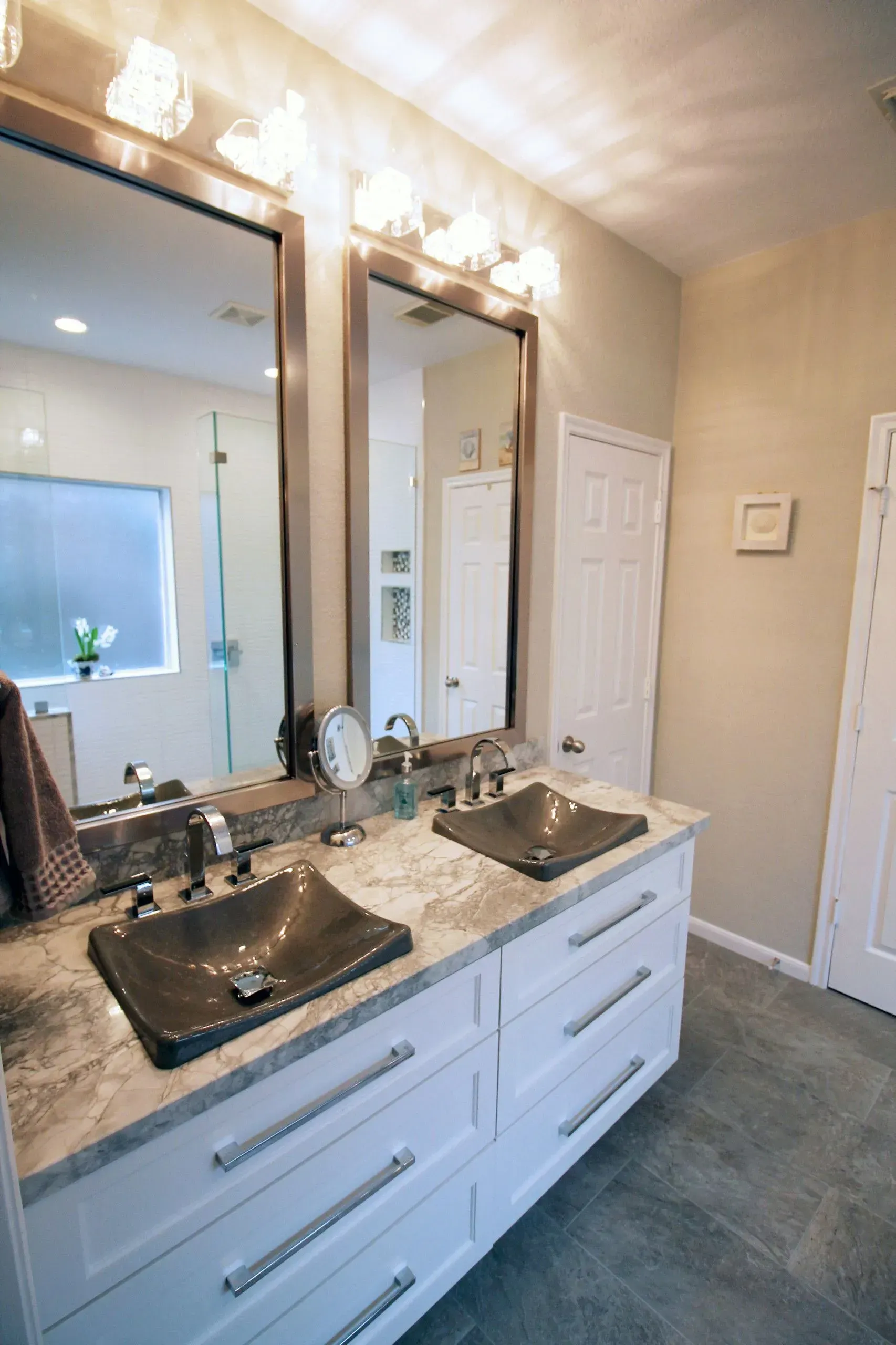 Modern bathroom vanity with double sinks, large mirror, and wall lights