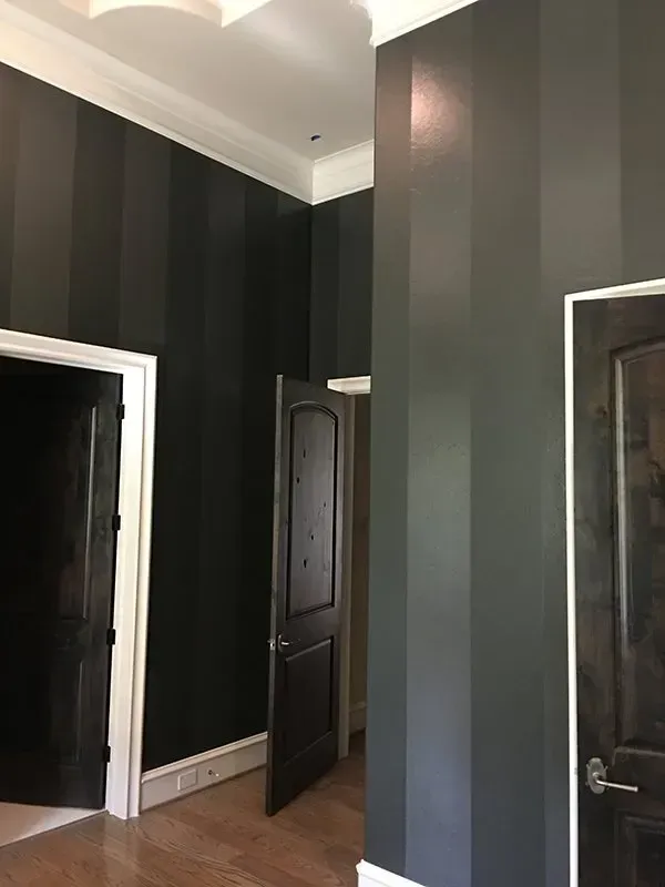 Interior hallway with dark striped walls, white trim, and multiple doorways.