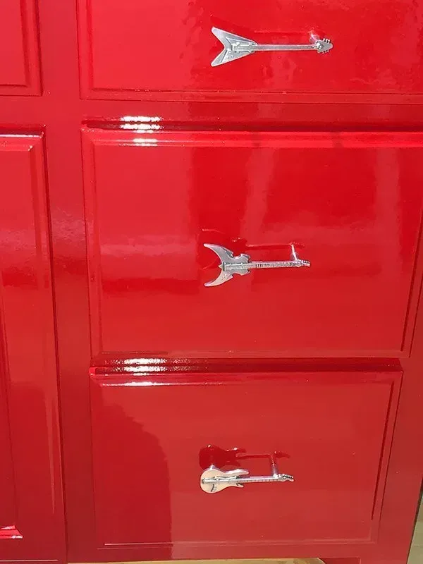 Red cabinet with three silver fish-shaped drawer pulls