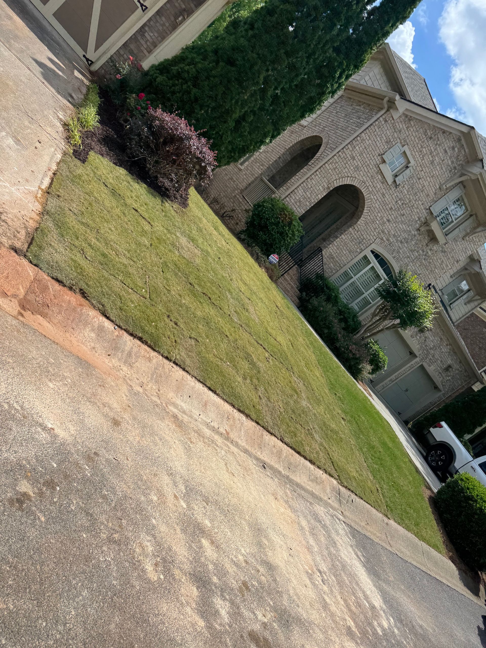 A large brick house with a lush green lawn in front of it.