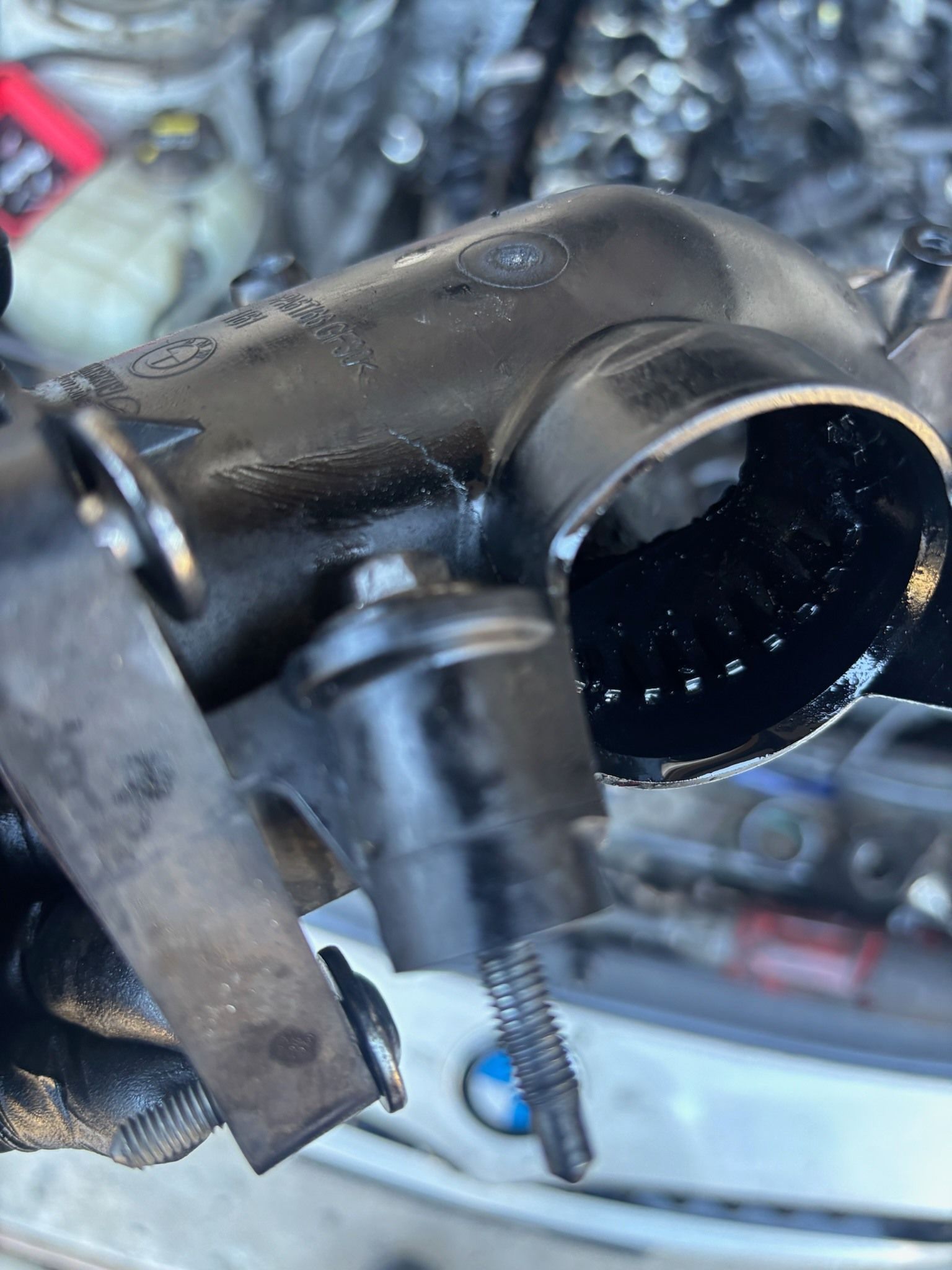 Close-up of a black bicycle stem with an attached cable in a workshop-like setting.
