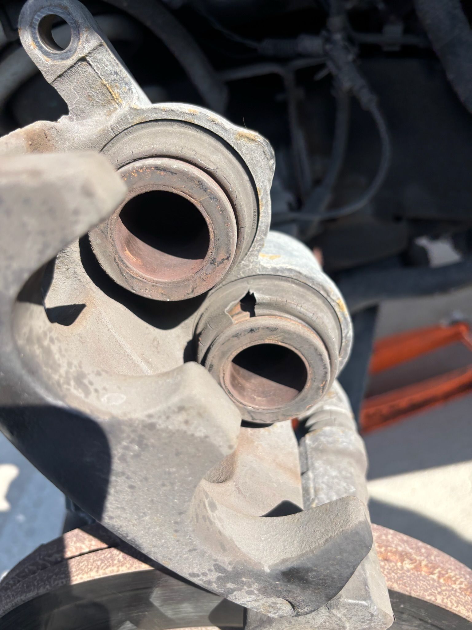 Close-up of a dusty car brake caliper and rotor during repair