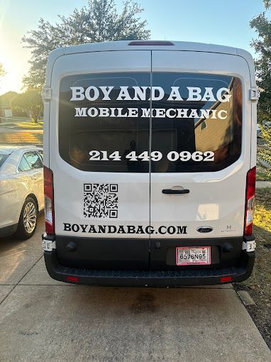 White mobile mechanic van with “Boy and a Bag,” phone number, website, and QR code on the back.