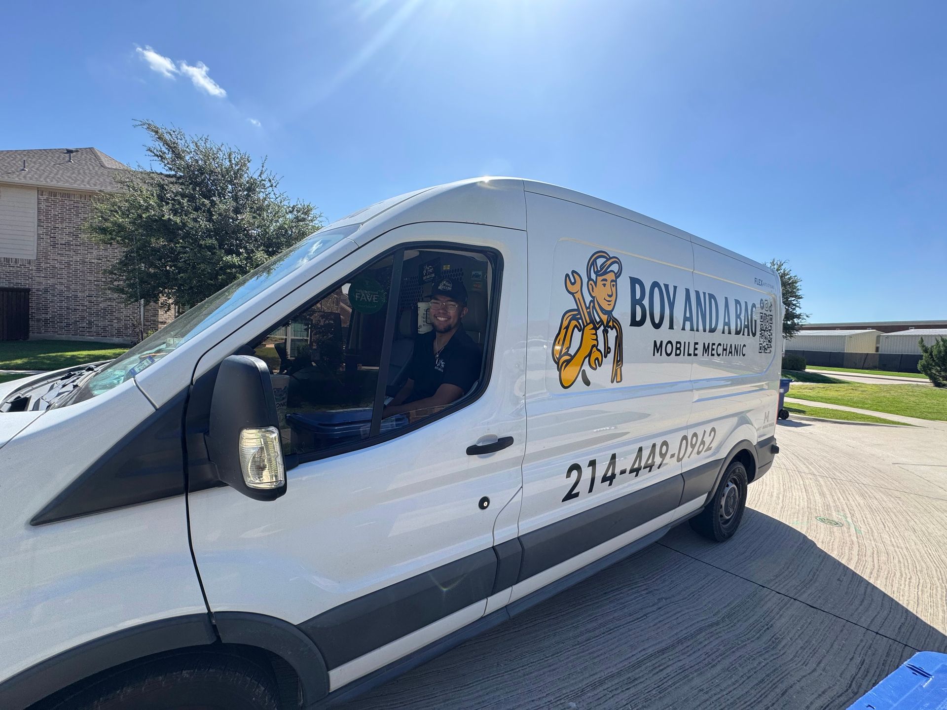 White delivery van with a driver, parked on a sunny street with a business logo on the side