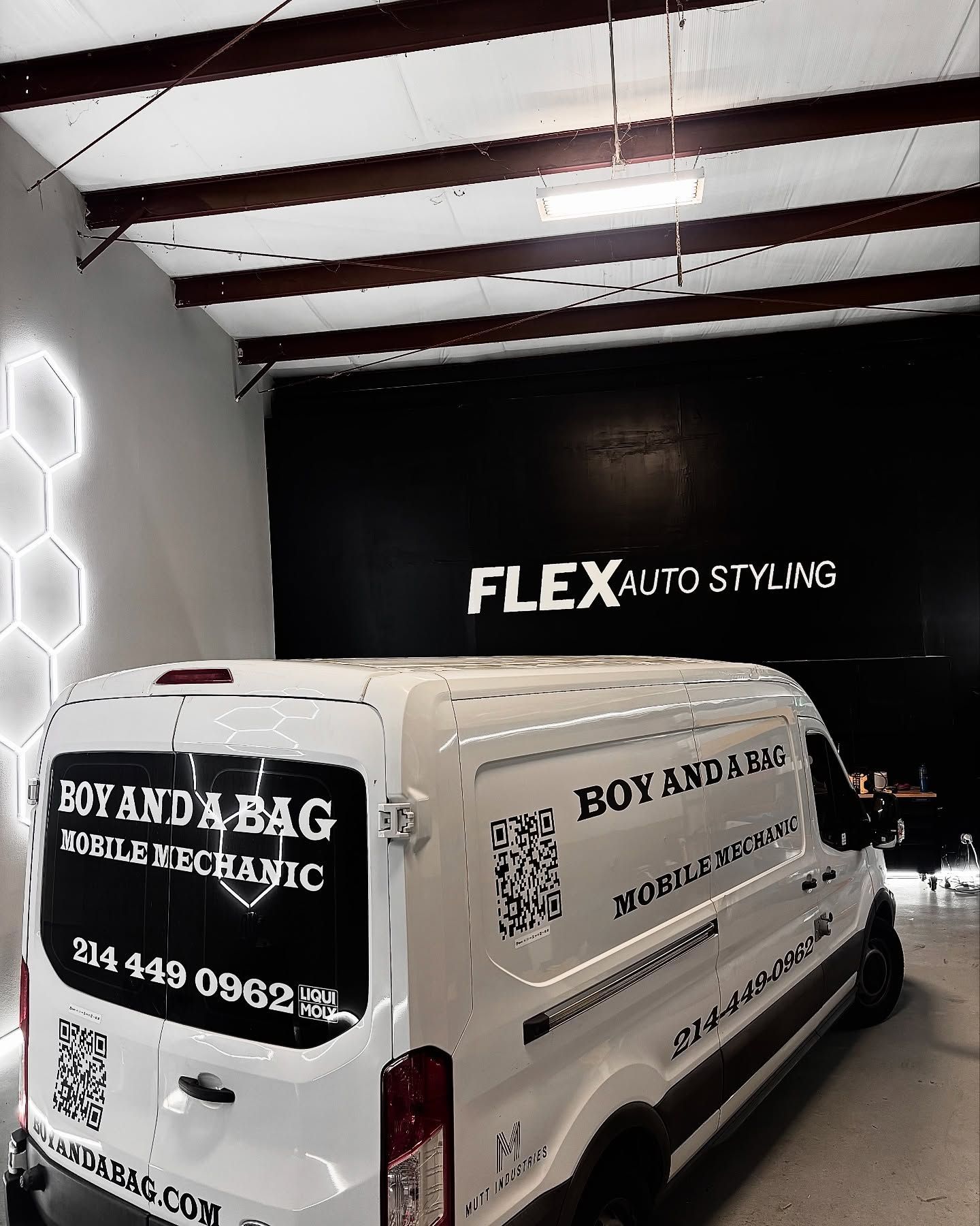 White branded van parked inside an auto styling shop with a black FLEX AUTOSTYLING wall logo.