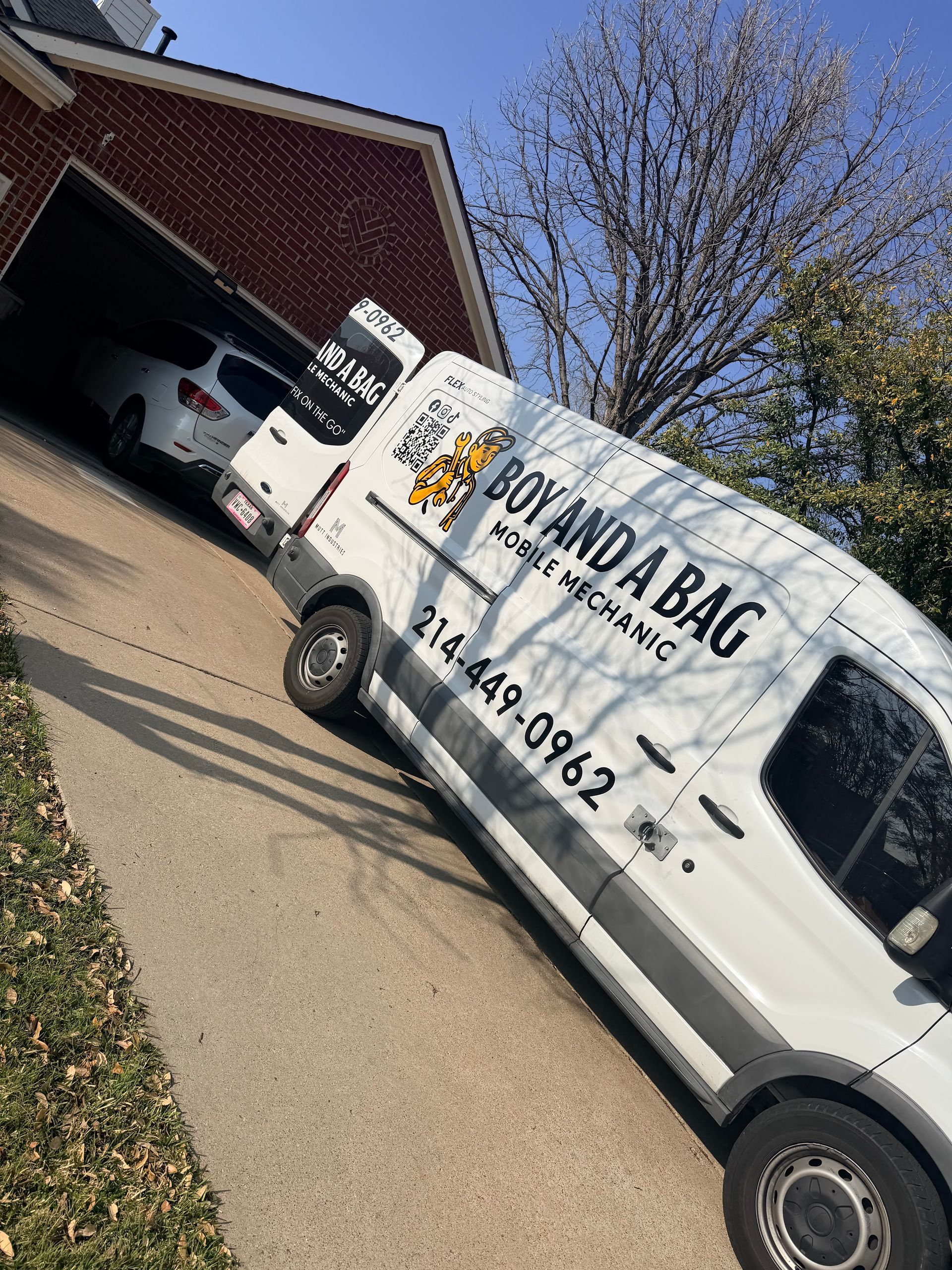 White business van with “YOU AND BACK” parked in a driveway beside an open garage on a sunny day