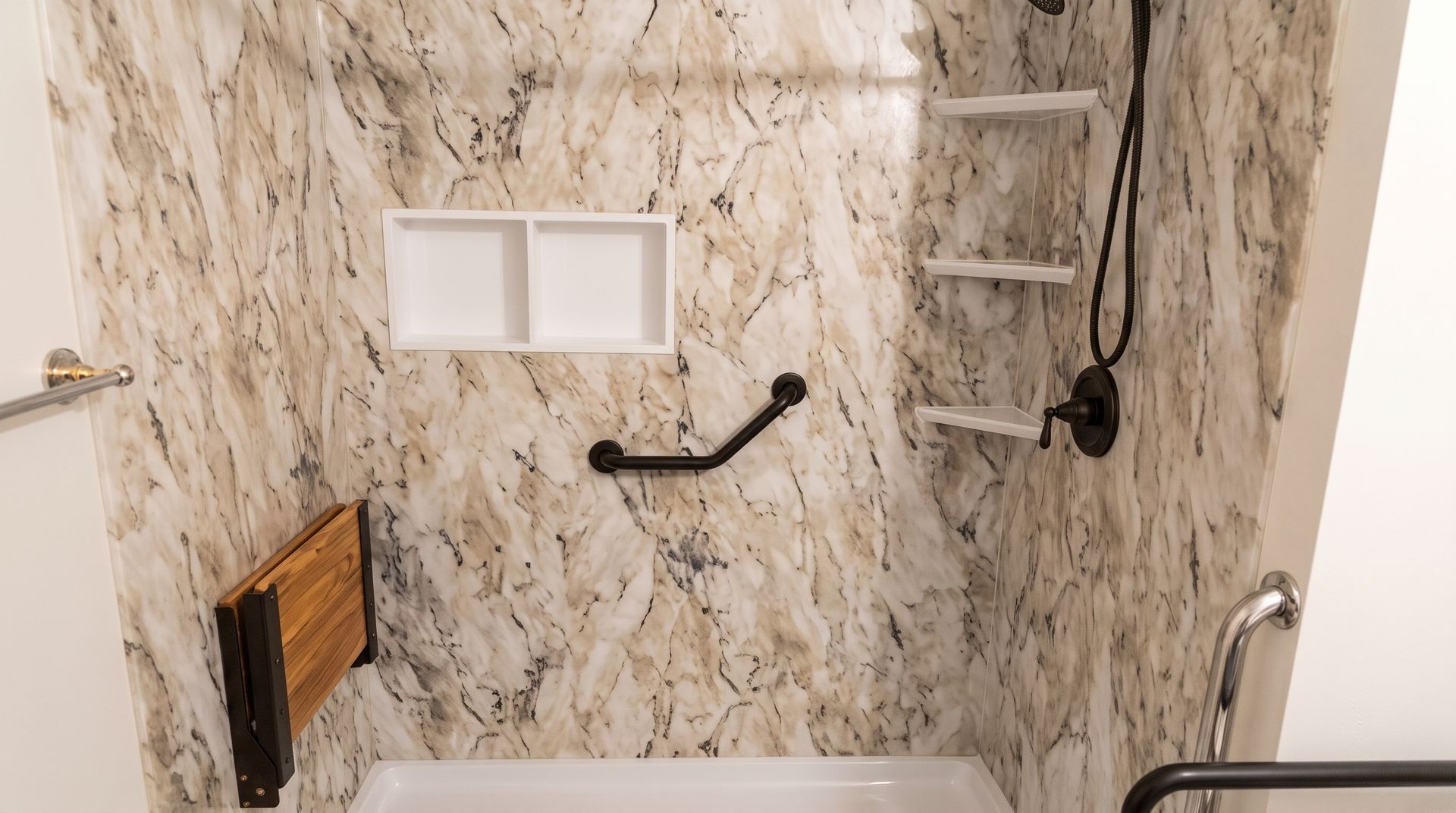 Bathroom with marble-patterned walls, built-in shelves, grab bars, and a bathtub