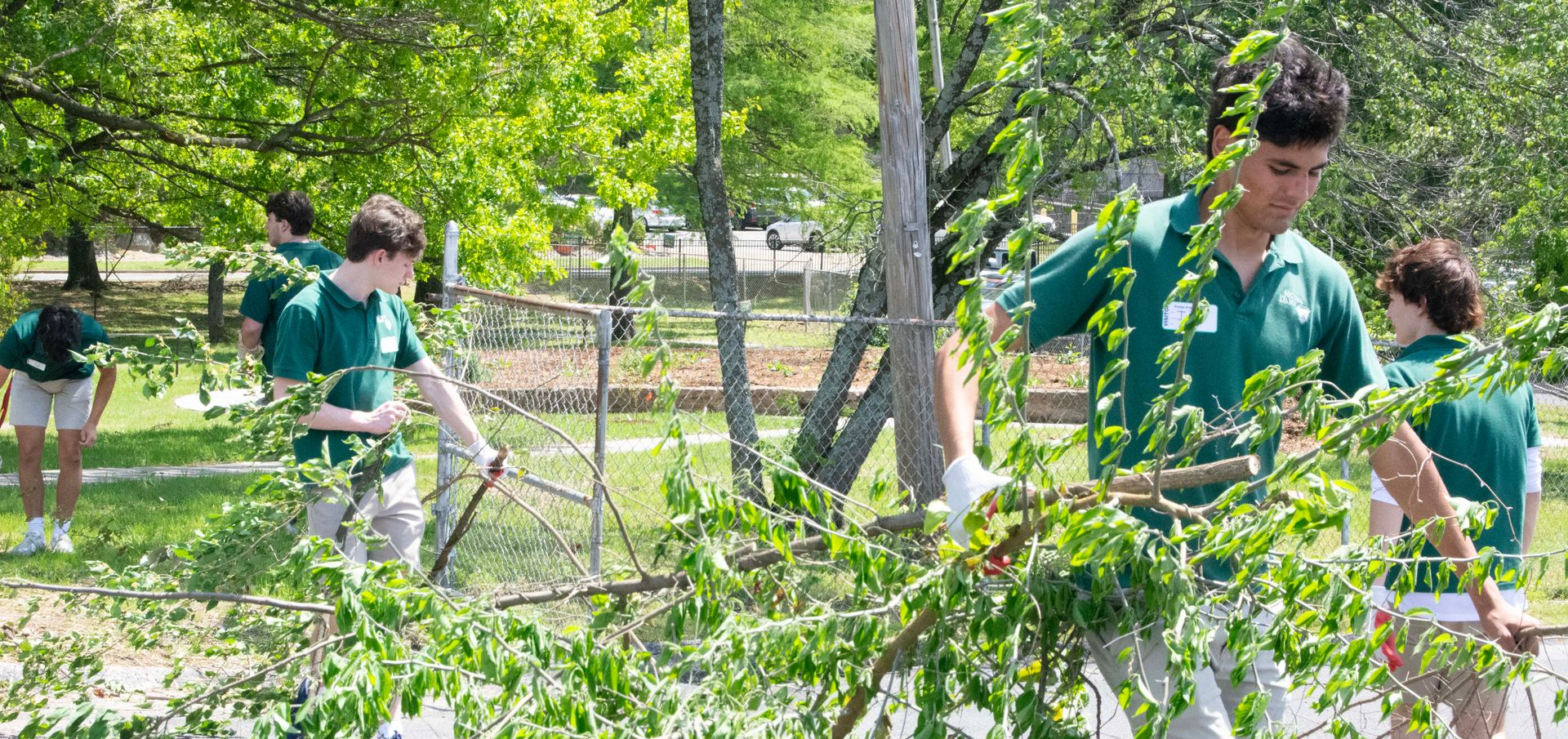 A group of Notre Dame student volunteers carry brush as part of an Orange Grove landscaping project.