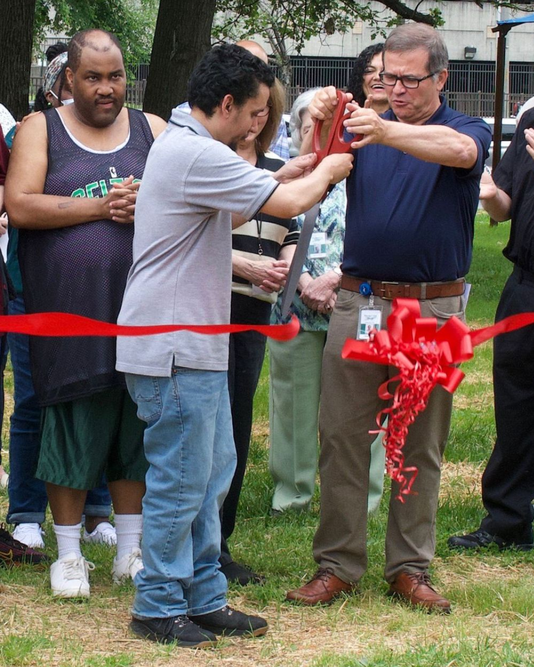 Members of the Orange Grove community cutting a ribbon to open a new playground at Orange Grove's main campus.