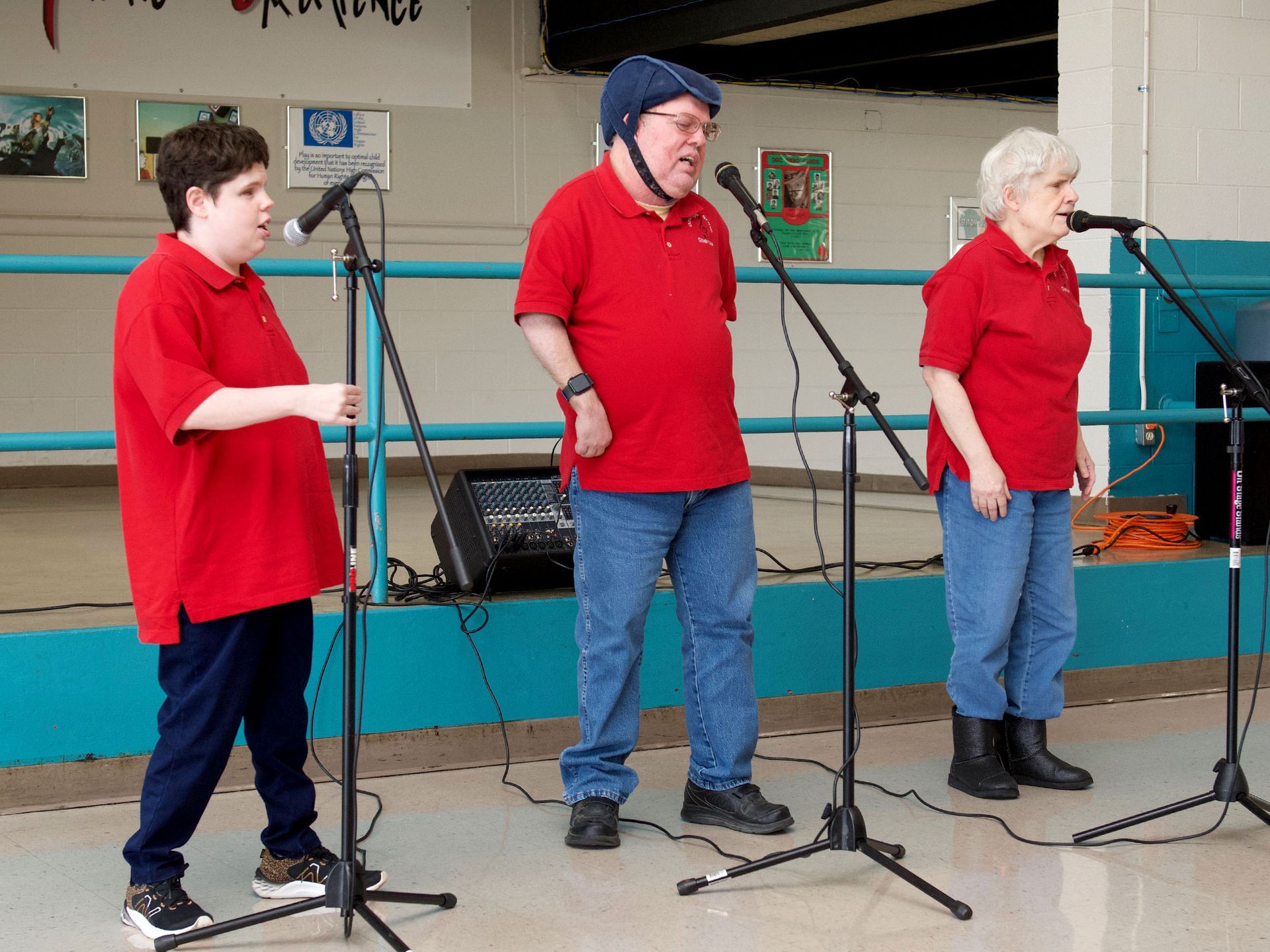 Orange Grove's Platinum Singers trio, wearing matching red polo shirts as they perform.