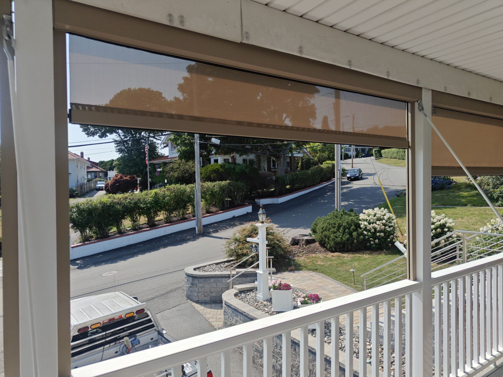 Balconies with beige awnings and a patio table beneath red-tiled roofs