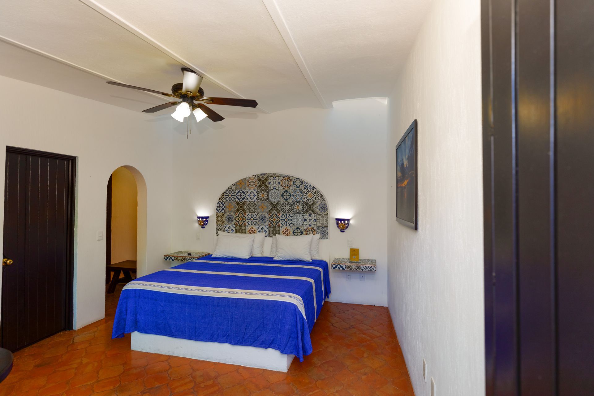 A bedroom with a large bed and a ceiling fan