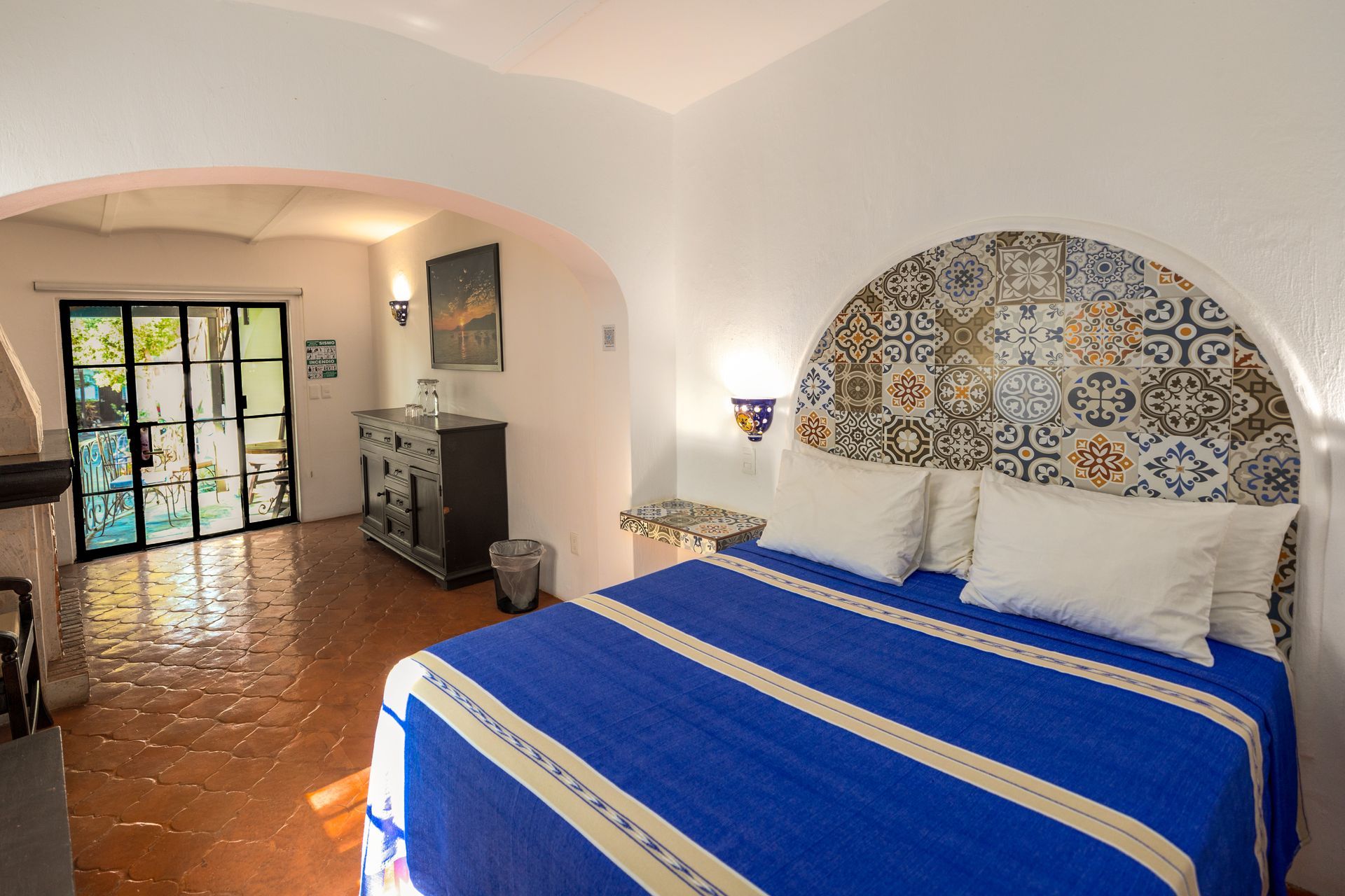 A bedroom with a king size bed and a blue blanket.
