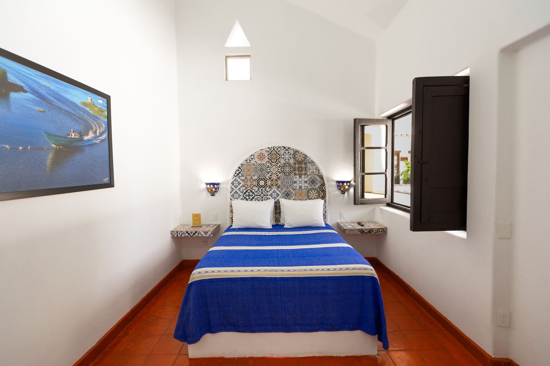 A bedroom with a bed and a television on the wall.
