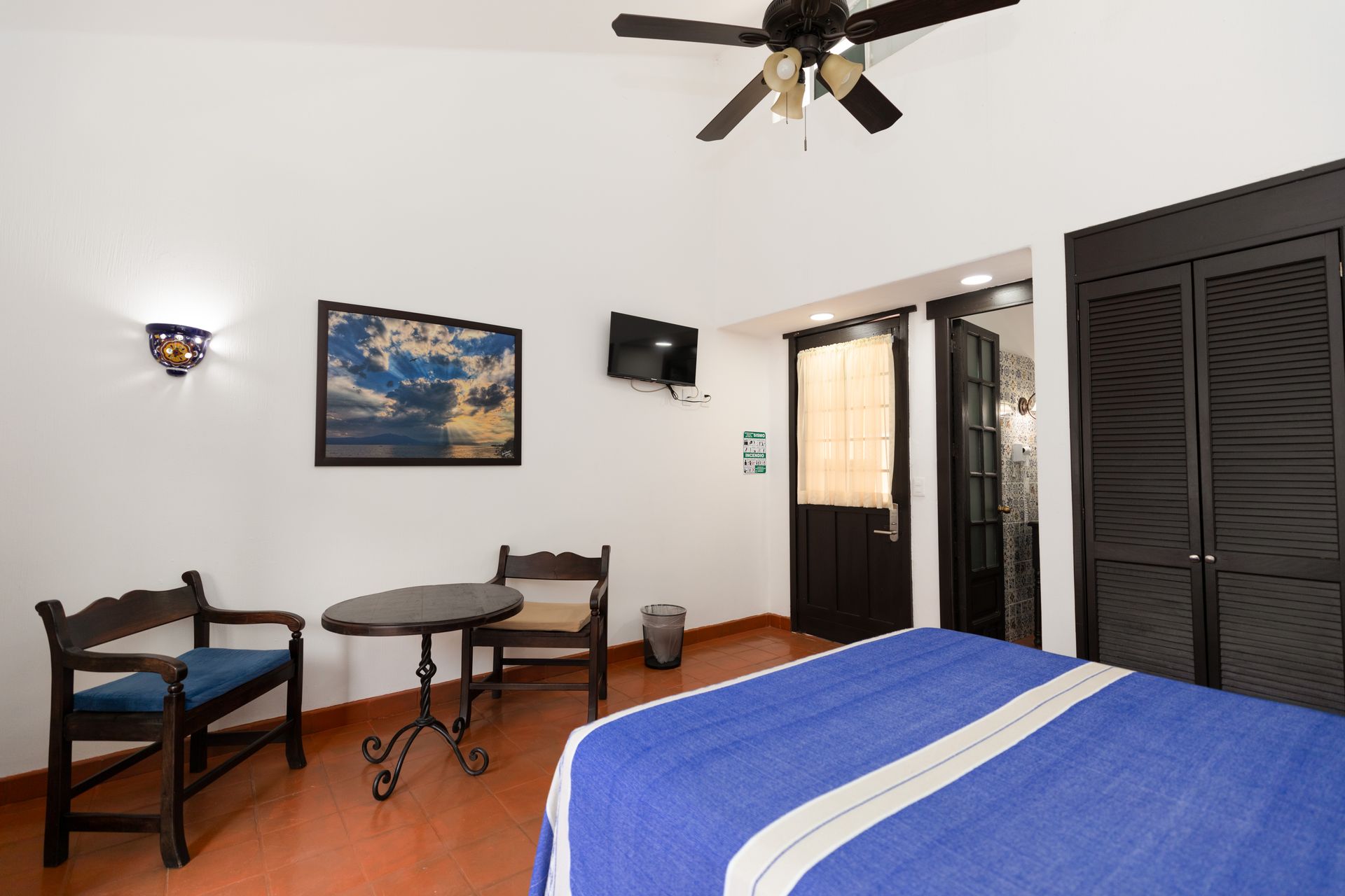 A hotel room with a bed , table and chairs