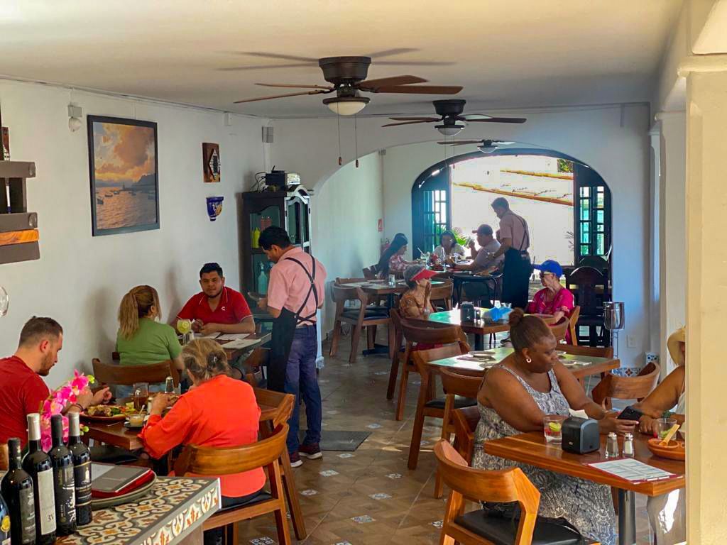 A group of people are sitting at tables in a restaurant.