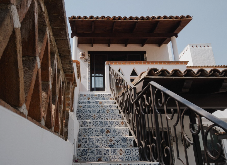 A set of stairs leading up to a house with a wrought iron railing.
