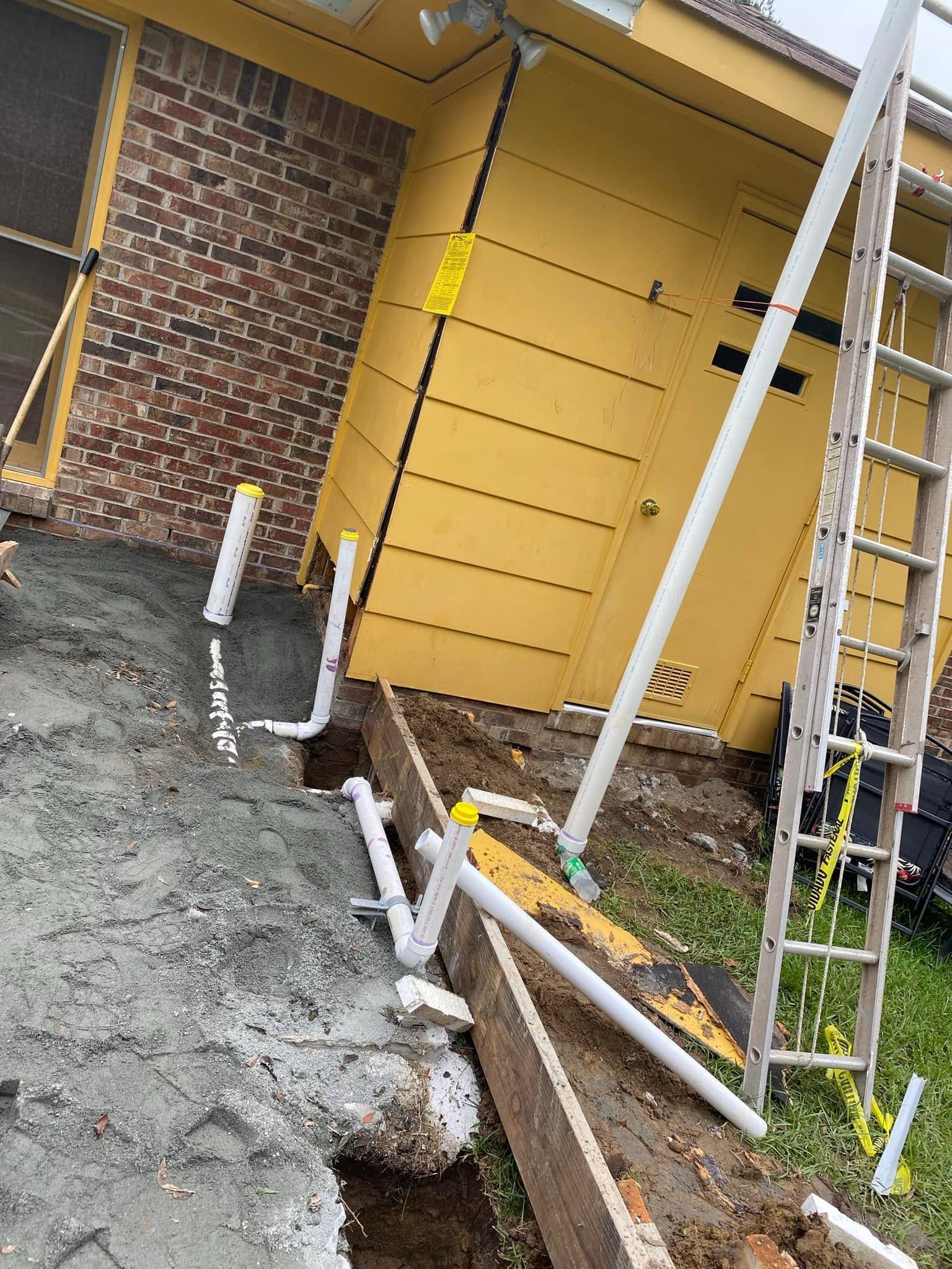 Tilted yellow house wall beside muddy construction debris and leaning ladder