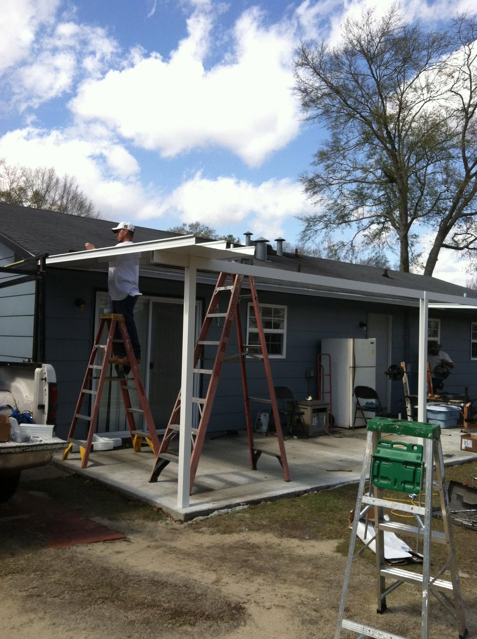 Two ladders at a house under roof repair on a cloudy day