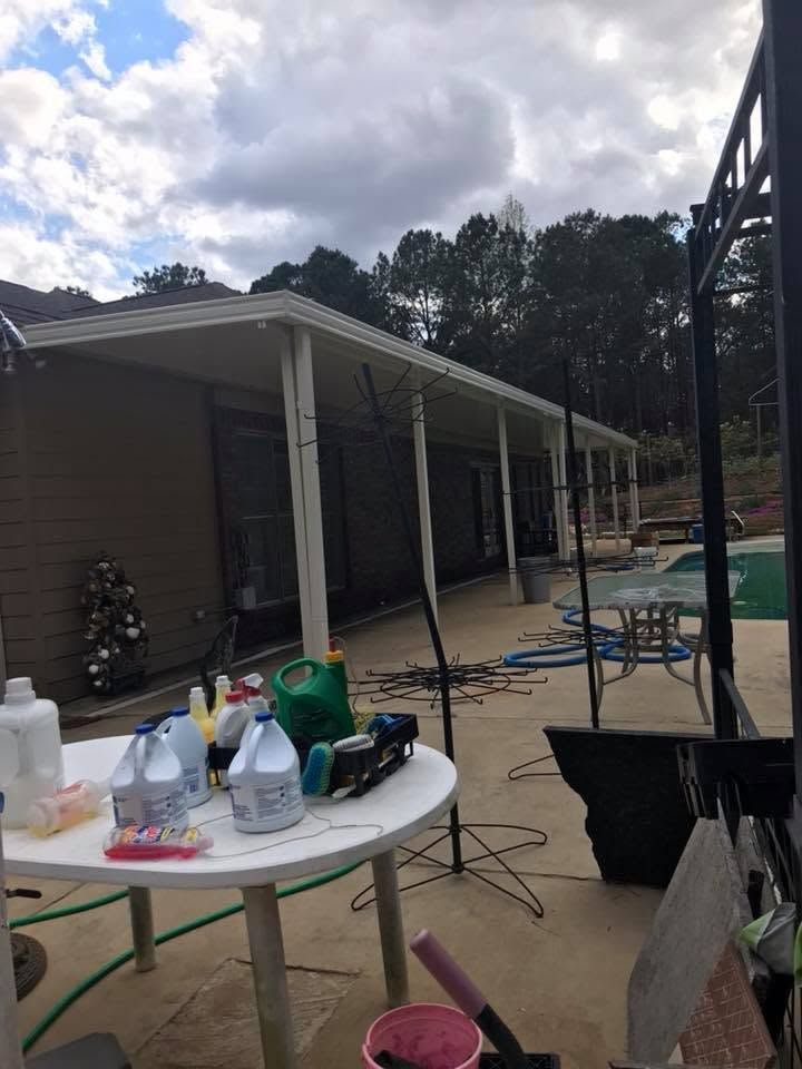 Backyard patio with tables, chairs, a pool, and a covered porch beside a house