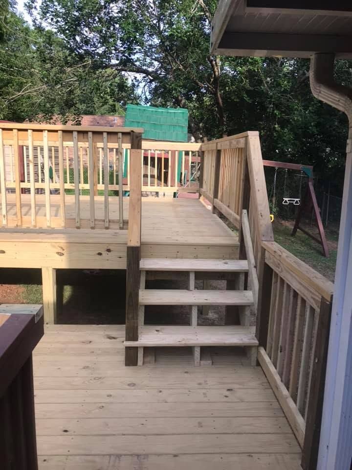 Wooden deck with steps and railings in a wooded backyard
