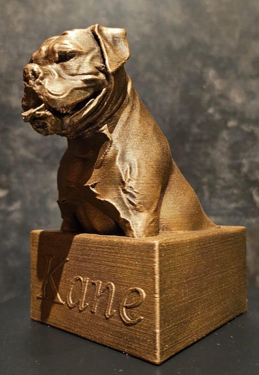 Een bronskleurige, 3D-geprinte buste van een bulldog op een rechthoekige sokkel, gegraveerd met de naam 