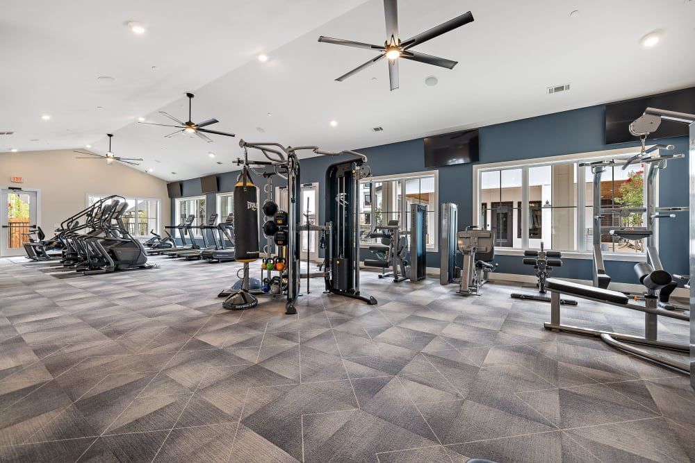 A large gym with a lot of equipment and a ceiling fan at The Avery, which offers apartments in North Austin.