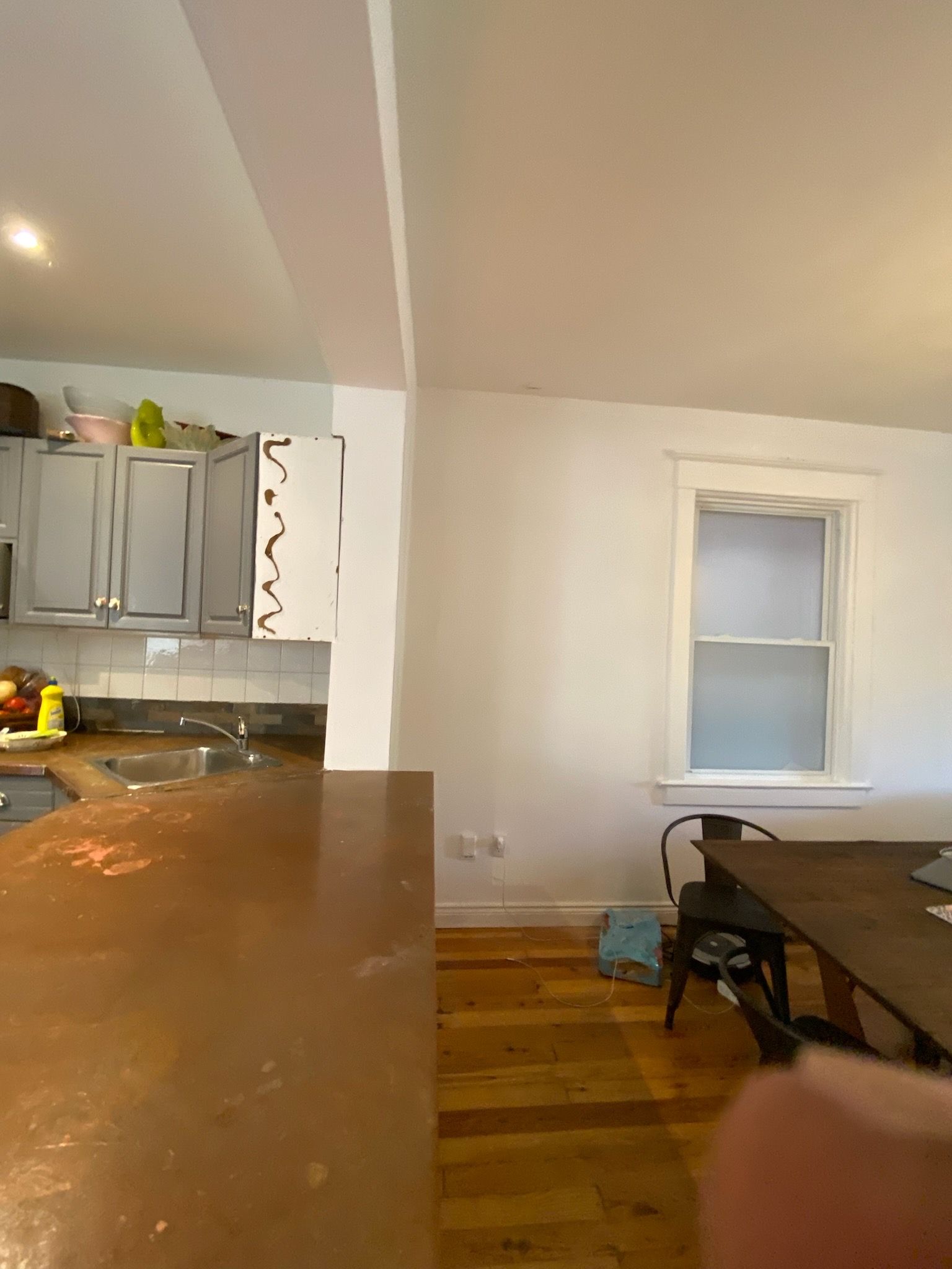 Kitchen with cabinets, countertop, window, and dining table.